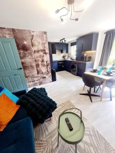 a living room with a blue couch and a table at Modern Apartment - FREE parking in Glasgow +16 photos