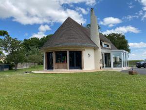 a small house with a roof on a lawn at La maison normande in Rots