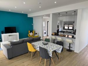 a living room with a couch and a table with chairs at Beautiful Modern Townhouse with Parking Included in Machico