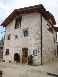 un grande edificio in pietra con una porta in legno di Agroturismo Urrutia a Osma
