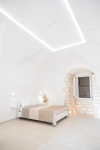 a white bedroom with a bed and a fireplace at Maison al Duomo in Vieste +11 photos