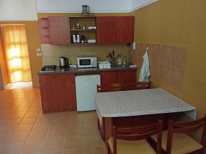 a small kitchen with a table and a microwave at 20 Bakancs Apartman in Esztergom +8 photos