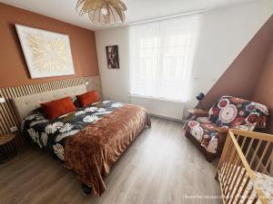 a bedroom with a bed and a chair and a window at Au Cœur de Boulogne in Boulogne-sur-Mer