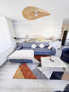 a living room with a blue couch and a table at Au Cœur de Boulogne in Boulogne-sur-Mer