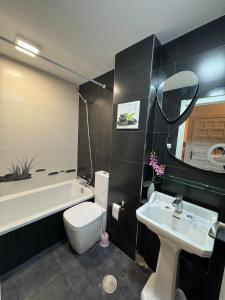 e bagno con lavandino, servizi igienici e vasca. di Dúplex Horta de Carlota a O Grove Altre 24 foto