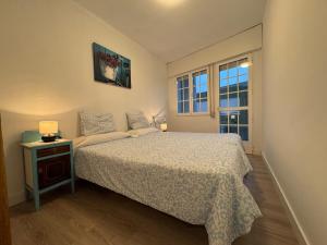 una piccola camera da letto con un letto e una finestra di Dúplex Horta de Carlota a O Grove