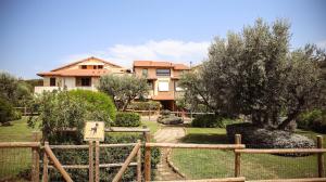 a house with a fence in front of a yard at Capalbio Relax - Super terrazza in Capalbio