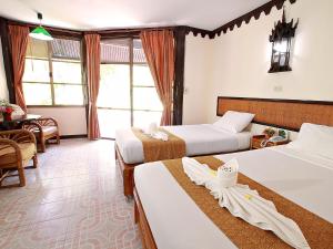 Cette chambre comprend 2 lits et une table. dans l'établissement Pung-Waan Resort, à Sai Yok