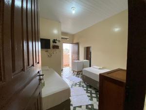 a hotel room with two beds and a bathroom at Junior Hotel in Anapu