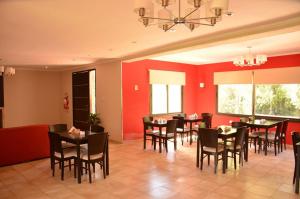 a dining room with tables and chairs and red walls at Las Marías in Chilecito