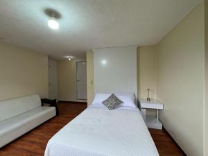 una camera da letto con un letto bianco e un divano di Luxury Mansion with Garden 6 Bedroom 6 Bath a Baños