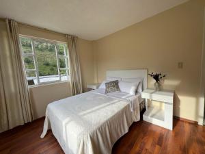 una camera da letto con un letto bianco e una finestra di Luxury Mansion with Garden 6 Bedroom 6 Bath a Baños