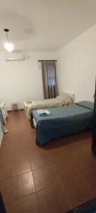 two beds in a room with a tiled floor at Las Magnolias in San Miguel +29 photos