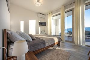a bedroom with a bed with a view of the ocean at Villa Mandarin Paradise with sea view in Pinezici +58 photos