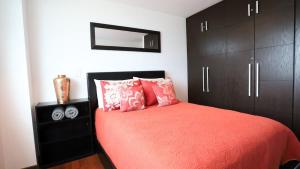 a bedroom with a red bed with black cabinets at Park Cimas 3 BR 2 BA Monumental Playas de Tijuana in Tijuana