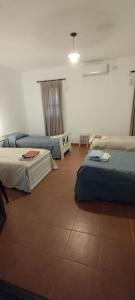 a room with three beds and a tiled floor at Las Magnolias in San Miguel