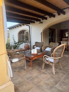 un patio con sillas de mimbre y una mesa de madera. en Finca la Jarra, en Benitachell 38 fotos más