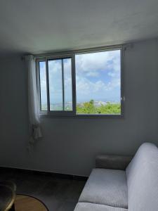 a bedroom with a window with a bed in it at Appartement élégant avec vue et climatisation in Fort-de-France
