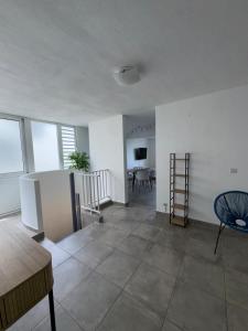 an empty living room with a table and chairs at Appartement élégant avec vue et climatisation in Fort-de-France