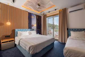 a hotel room with two beds and a window at Greek House Hotel in Neos Marmaras