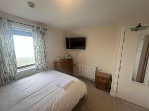 une chambre avec un lit et une télévision à écran plat dans l'établissement The Westings, à Tingwall