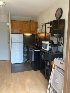 a kitchen with a white refrigerator and a microwave at Studio Barèges in Barèges +9 photos