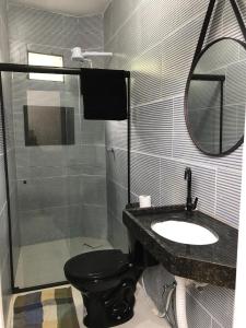 a bathroom with a toilet and a sink and a mirror at Especial Beira Mar in Maragogi