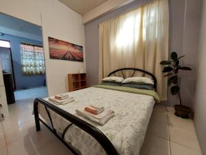 Un dormitorio con una cama con toallas. en GGGO RESIDENCES, Studio 103, King, en Sorsogon