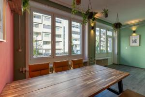 un tavolo con sedie in una stanza con finestre di MUE Cubes - Capsule Hotel a Basilea
