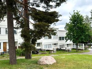 a white building with trees in front of it at Unique House only 3 min from the airport in Vantaa