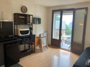 a living room with a microwave and a balcony at Studio avec balcon Barèges in Barèges