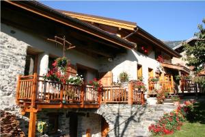 a house with a balcony with flowers on it at Auberge de Cassiel in La Côte-dʼAime