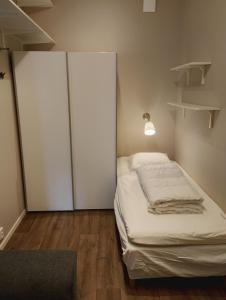 a bedroom with a bed with a closet and a lamp at Cozy cottage with lake view in Grimeton