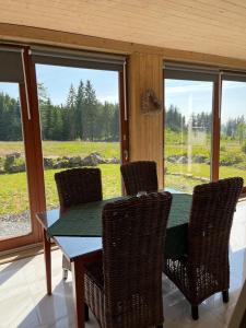 a dining room with a table and chairs and windows at Novoveská chaloupka in Stříbrná +11 photos