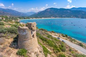 an old castle on a hill next to a body of water at Le Cosy Corse in Vico