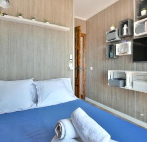 a bedroom with a blue bed with towels on it at Casa Marvista - piscina, barbacoa y vistas al mar in Pineda de Mar +73 photos