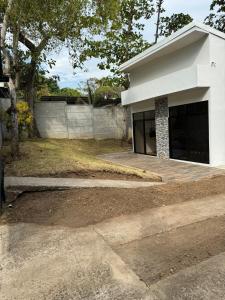 ein weißes Haus mit einem Zaun davor in der Unterkunft Casa vacacional a 5min de la Playa in Morales + 10 Fotos