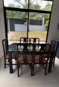 ein Esstisch mit Stühlen und einem Fenster in der Unterkunft Casa vacacional a 5min de la Playa in Morales