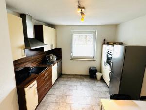アシャッフェンブルクにあるApartment Aschaffenburgのキッチン(ステンレス製の冷蔵庫付)、窓が備わります。