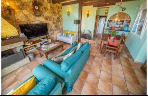 a living room with a blue couch and a tv at Casa Marvista - piscina, barbacoa y vistas al mar in Pineda de Mar