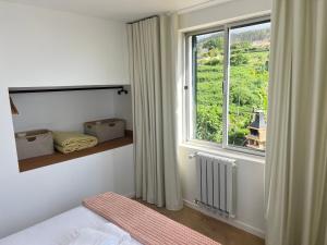 a bedroom with a bed and a large window at Villa do Monte Sunset in Porto Moniz