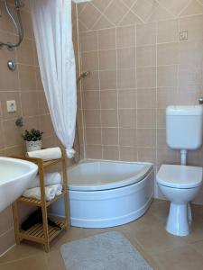 a bathroom with a tub and a toilet and a sink at APP Mirela 3 in Novi Vinodolski
