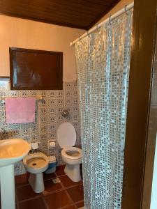 a bathroom with a toilet and a sink and a shower at Casa Pé na Areia 027 QUARTO CASAL 1 in Guarapari