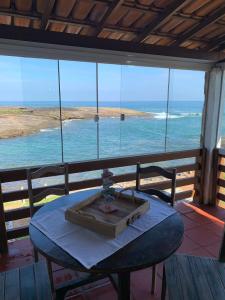 a table in a room with a view of the ocean at Casa Pé na Areia 027 QUARTO CASAL 1 in Guarapari +3 photos