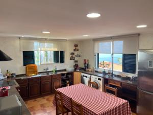 a kitchen with a table with a red and white checkered table cloth at Villa do Monte Sunset in Porto Moniz