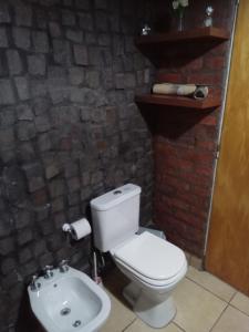 a bathroom with a white toilet and a sink at Lo de iaia in Carpintería +15 photos