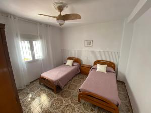 a room with two beds and a ceiling fan at Vivienda rural en Pegalajar in Pegalajar