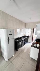a kitchen with a white refrigerator and a stove at Suíte privativa no centro da capital in Palmas