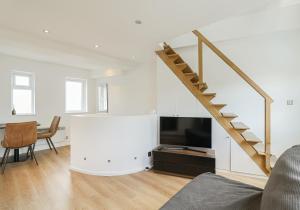 sala de estar con escalera y TV de pantalla plana en Apartment near Harrods, en Londres