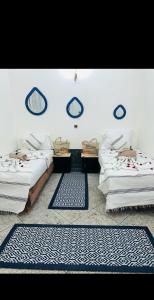 deux lits dans une chambre avec des tapis bleus et blancs dans l'établissement Les 3 SOEURS MAJORELLE, à Marrakech 35 autres photos